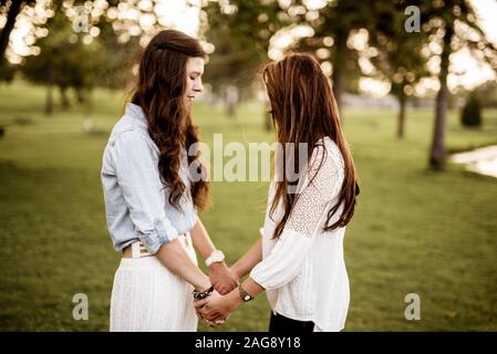 Nahaufnahme von zwei Frauen, die beim Beten die Hände halten Ein unscharfer Hintergrund Stockfoto