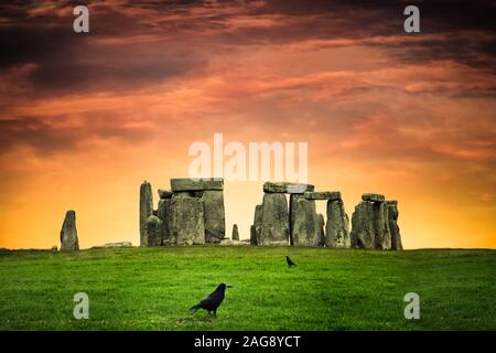 Stonehenge unter bunten Sonnenuntergang mit schwarze Krähen Stockfoto