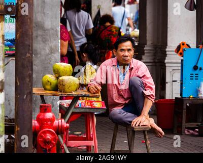 HAIKOU, HAINAN, CHINA - Mar 2 2019 - einem Straßenhändler verkaufen frische Kokosnüsse mit Kokosnuss Wasser, ein beliebtes tropisches Getränk. Stockfoto