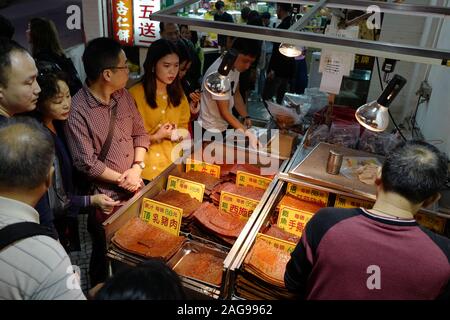 (191218) - Macau, Dez. 18, 2019 (Xinhua) - die Menschen kaufen Lebensmittel Spezialitäten, die in einer Gasse in der Nähe der Ruinen von St. Paul's in Macao, China, Dez. 16, 2019. In den letzten zwei Jahrzehnten, die special administrative region hat große Fortschritte in der wirtschaftlichen Entwicklung gemacht und erreichten Wohlstand und Stabilität unter dem Grundsatz "ein Land, zwei Systeme". (Xinhua / Meng Tao) Stockfoto