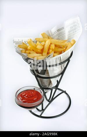 Pommes frites mit Ketchup in einem Papierkegel auf einem Frittierhalter isoliert auf weißem Hintergrund Stockfoto