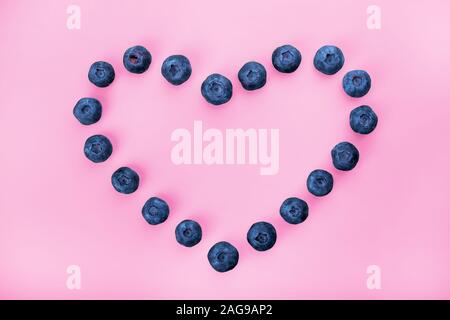 Blueberry Beeren herzförmigen liegen auf einem rosa Hintergrund. Stockfoto