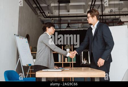 Zwei glückliche zufriedene Geschäftsleute Händeschütteln über Stockfoto