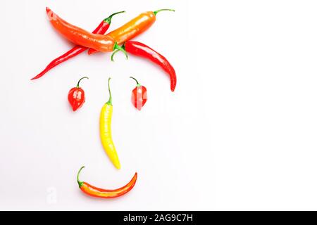 Gerne Rote und gelbe Paprika Pfeffer Gesicht lächelnd, auf weißem Hintergrund. Gesundheit, Ernährung, vegan, lustiges Konzept. Stockfoto