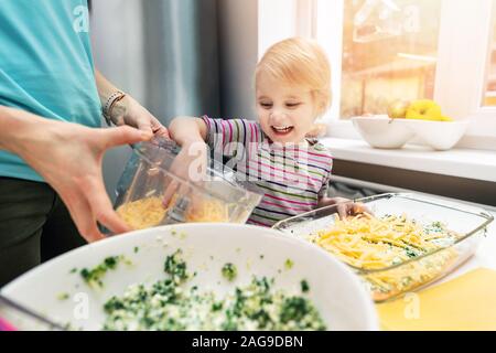 Mutter und Tochter kochen vegetarische Lasagne gemeinsam in der Küche zu Hause Stockfoto