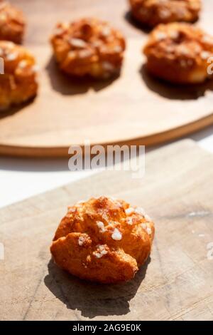 Nahaufnahme von einigen chouquettes, Gebäck typisch für Frankreich, auf einem Tisch Stockfoto