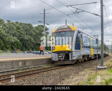 AUCKLAND, Neuseeland - Dec 12, 2015: ein Low Angle Shot eines gelben Zug unter der Sturmwolken in Auckland, Neuseeland Stockfoto