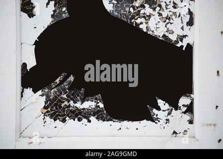 Ein zerbrochenes Fenster in der Tür, mit scharfen, gefährliche Kanten von Splitter- und abblätternde Farbe. Stockfoto