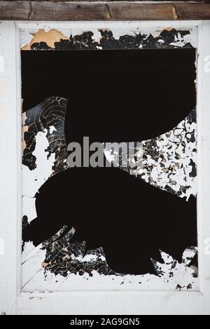 Ein zerbrochenes Fenster in der Tür, mit scharfen, gefährliche Kanten von Splitter- und abblätternde Farbe. Stockfoto
