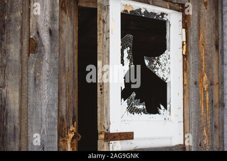 Ein zerbrochenes Fenster in der Tür, mit scharfen, gefährliche Kanten von Splitter- und abblätternde Farbe. Stockfoto