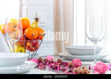 Selektive Aufnahme eines modernen Tischs mit Blumenblättern, Obst und schönem Besteck Stockfoto