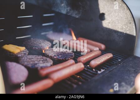 Nahaufnahme von Wurst und Hamburger Fleisch auf dem Grill Stockfoto