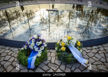 Berlin, Deutschland. 18 Dez, 2019. Zwei Kränze von Blumen aus der Botschaft des Staates Israel (L-R) und der Zentralrat der deutschen Sinti und Roma liegen auf das Denkmal für die Sinti und Roma in Europa während des Nationalsozialismus zwischen dem Brandenburger Tor und der Reichstag ermordet. Credit: Gregor Fischer/dpa/Alamy leben Nachrichten Stockfoto