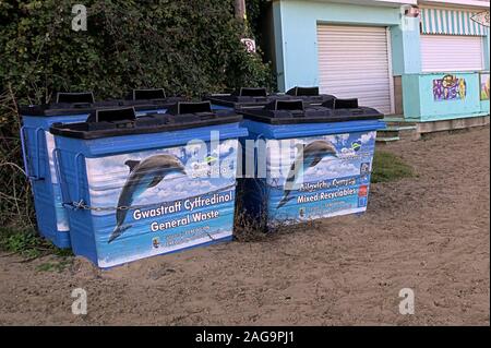 Vier große und Recycling von Abfällen Mülltonnen am Strand mit Ceredigion Delphin logo Stockfoto