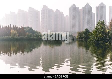 Die traditionelle chinesische Architektur Halbkreisbrücke über die Flüsse Fuhe und Jiangan im Nanhu Wetland Park von Chengdu, Sichuan, China. Luftverschmutzung Stockfoto