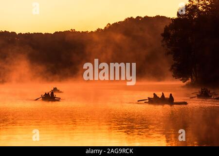 Silhouette der Rafting Boot im Goldenen misty See unter der warmen Morgensonne in Pang Ung Stockfoto