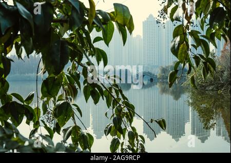 Die traditionelle chinesische Architektur Halbkreisbrücke über die Flüsse Fuhe und Jiangan im Nanhu Wetland Park von Chengdu, Sichuan, China. Luftverschmutzung Stockfoto