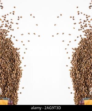Vertikale Aufnahme von Kaffeebohnen, die aus dem verschüttet wurden Beutel auf einer weißen Oberfläche Stockfoto