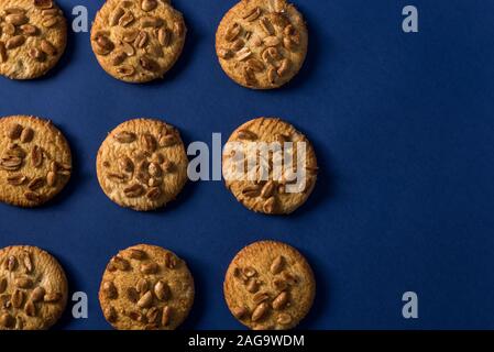 Hausgemachte gesunde Cookies mit gerösteten Erdnüssen auf einem blauen Hintergrund mit Platz für Ihren Text Stockfoto