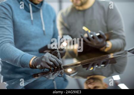 Inspektor messen Farbe bedecken Dicke der Karosserie am Fahrzeug Service box Blick auf Händen und professionelle Stärke m Stockfoto