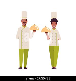 Köche paar professionelle Köche Holding abgedeckt Platten Serviertablett afrikanische amerikanische Frau Mann restaurant Arbeiter in Uniform stehend zusammen kochen Konzept Flachbild voller Länge Vektor illustration Stock Vektor