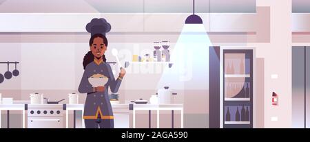 Weiblichen professionellen Chefkoch Halteplatte mit Porridge und Löffel african american Woman in Uniform Verkostung Gericht kochen Konzept moderne Restaurant Küche inneren flachen Portrait horizontale Vektor illustration Stock Vektor