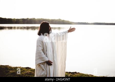 Shallow Focus Aufnahme von Jesus Christus mit den Händen nach oben Und in die Ferne schauen Stockfoto