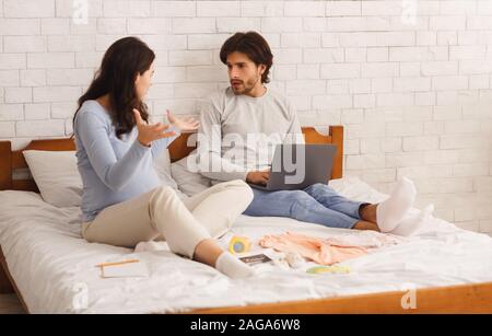 Junge schwangere paar Unstimmigkeiten während der Vorbereitung Checkliste für Krankenhaus Stockfoto