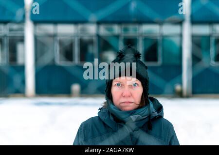 Besorgt betroffenen ernsthafte Frau hinter chain-link Fence als Hindernis auf kalten Wintertag Stockfoto