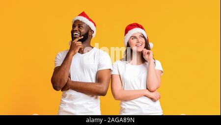 Nachdenklich Paar tragen Nikolausmützen und posieren mit nachdenklichen Gesichtsausdruck Stockfoto