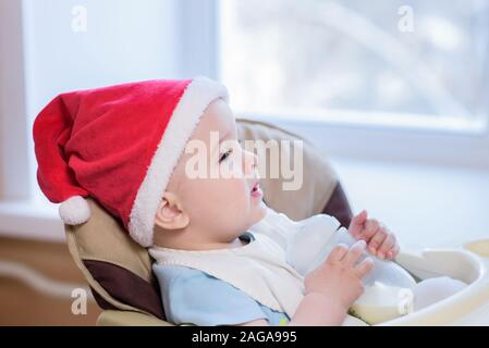 Kleinkind isst am Tisch in einem Weihnachten hat Stockfoto