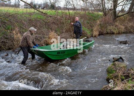 Zerbst, Sachsen-Anhalt, Deutschland. 18. Dez 2019. Jens Winterheuser (l) und Robert Wolf vom Institut für Binnenfischerei Potsdam-Sacrow Suche Laichen Lachs mit einem elektrischen Fanggeräte. Insgesamt 143.500 junge Lachse und Meerforellen 90,300 Jungtiere wurden in die nuthe in der Nähe von zerbst in den vergangenen zehn Jahren freigegeben. Die Fische an den Atlantik migrieren und Rückkehr in die nuthe nach ein paar Jahren, um zu laichen. Credit: Mattis Kaminer/Alamy leben Nachrichten Stockfoto