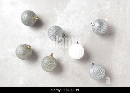 Silber und Gold Weihnachtsornamente mit einer weißen Kugel, horizontale Format auf einem hellgrauen Table Top. Stockfoto