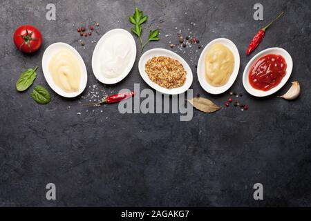 Satz von verschiedenen Saucen. Beliebte Saucen in Schalen - Ketchup, Senf, Mayonnaise. Ansicht von oben mit der Kopie. Flach Stockfoto