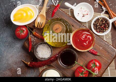 Satz von verschiedenen Saucen. Beliebte Saucen in Schalen - Ketchup, Senf, Mayonnaise. Ansicht von oben. Flach Stockfoto