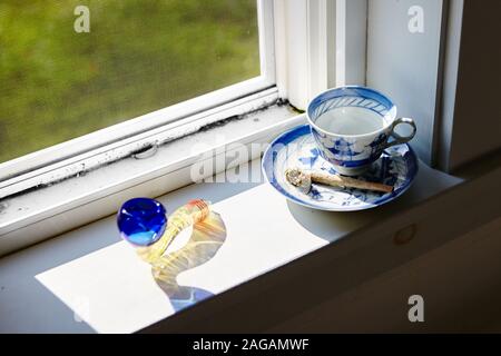 High-Angle-Aufnahme eines Marihuana stumpfen und trockenen Cannabis Auf einer Kaffeetasse in der Nähe des Fensters Stockfoto