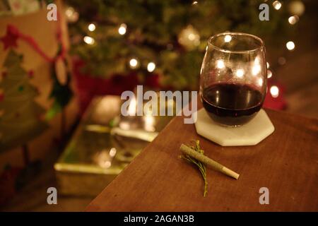 Nahaufnahme eines Marihuana-Blunt und eines Glas Cognac auf einem Tisch auf unscharfem Hintergrund Stockfoto