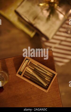 Vertikale High-Angle-Aufnahme einer Kiste mit Marihuana-Blunts Auf einem Holztisch Stockfoto