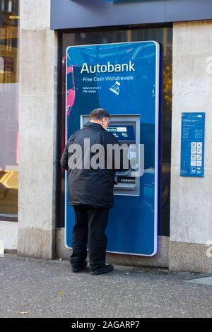 16. Oktober 2019 Ein Mann im mittleren Alter, die ein ATM in der geschäftigen Donegall Square West Belfast Nordirland. Stockfoto