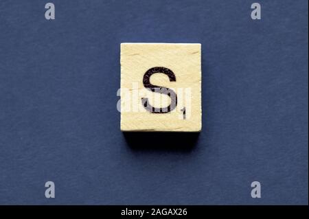 Buchstabe S auf einem Holzwürfel aus einem Wortspielbrett Spiel Stockfoto