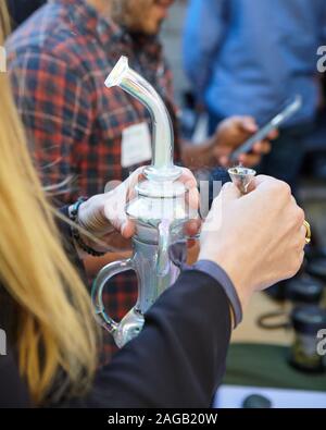 Eine vertikale closeup Schuß einer Person, die einen Cannabis bubbler von Cannabis Stockfoto