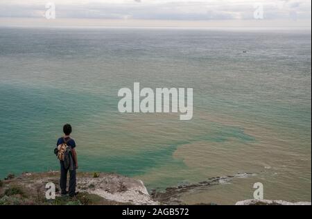 Mann stehen am Rand der Klippen bei Beachy Head, draußen auf dem Meer, Eastbourne, East Sussex, England, Großbritannien Stockfoto