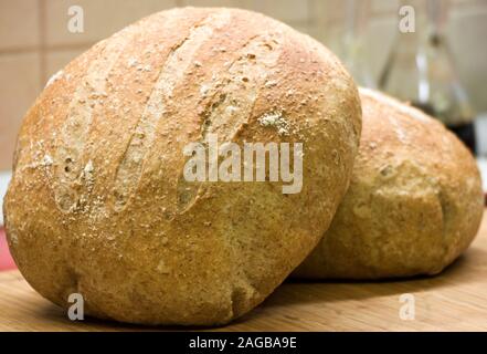 Frisch zubereitetes Sauerteigbrot mit Krummtextur. Zwei runde Laiben kühlen sich ab. Nahaufnahme. Stockfoto