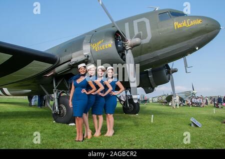 Zeitraum weibliche Flight Attendant Kostüme am Goodwood Revival 2014 im Freddie März Geist der Luftfahrt. Frauen in der Zeit von Kleid. C-47 Dakota Stockfoto