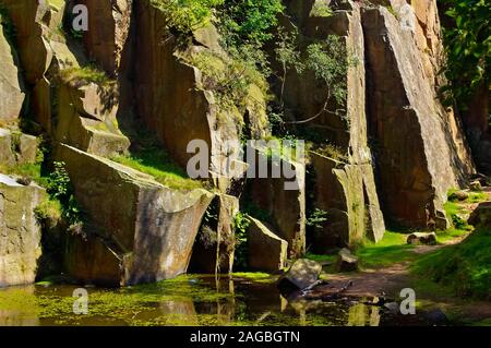 Abgebrochene gritstone Gesichter im Sonnenlicht arbeitete in Bole Hill Steinbruch in der Nähe von Grindleford, Peak District Stockfoto