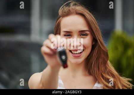 Portrait von fröhlichen Blondine mit Schlüssel von Ihrem nagelneuen Auto Stockfoto