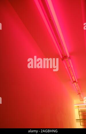 Vertikale Low-Angle-Aufnahme eines Flurs mit roten Lampen An der Decke Stockfoto