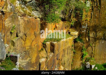 Abgebrochene gritstone Gesichter im Sonnenlicht arbeitete in Bole Hill Steinbruch in der Nähe von Grindleford, Peak District Stockfoto