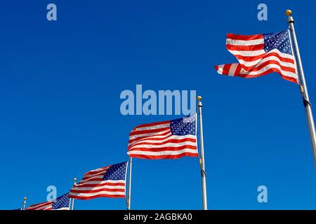 Amerikanische Fahnen gegen den tiefblauen Himmel am Washington Monument Stockfoto