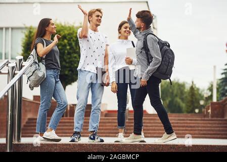 Geben hoch fünf. Gruppe von jungen Studenten in Freizeitkleidung in der Nähe der Universität am Tag Stockfoto